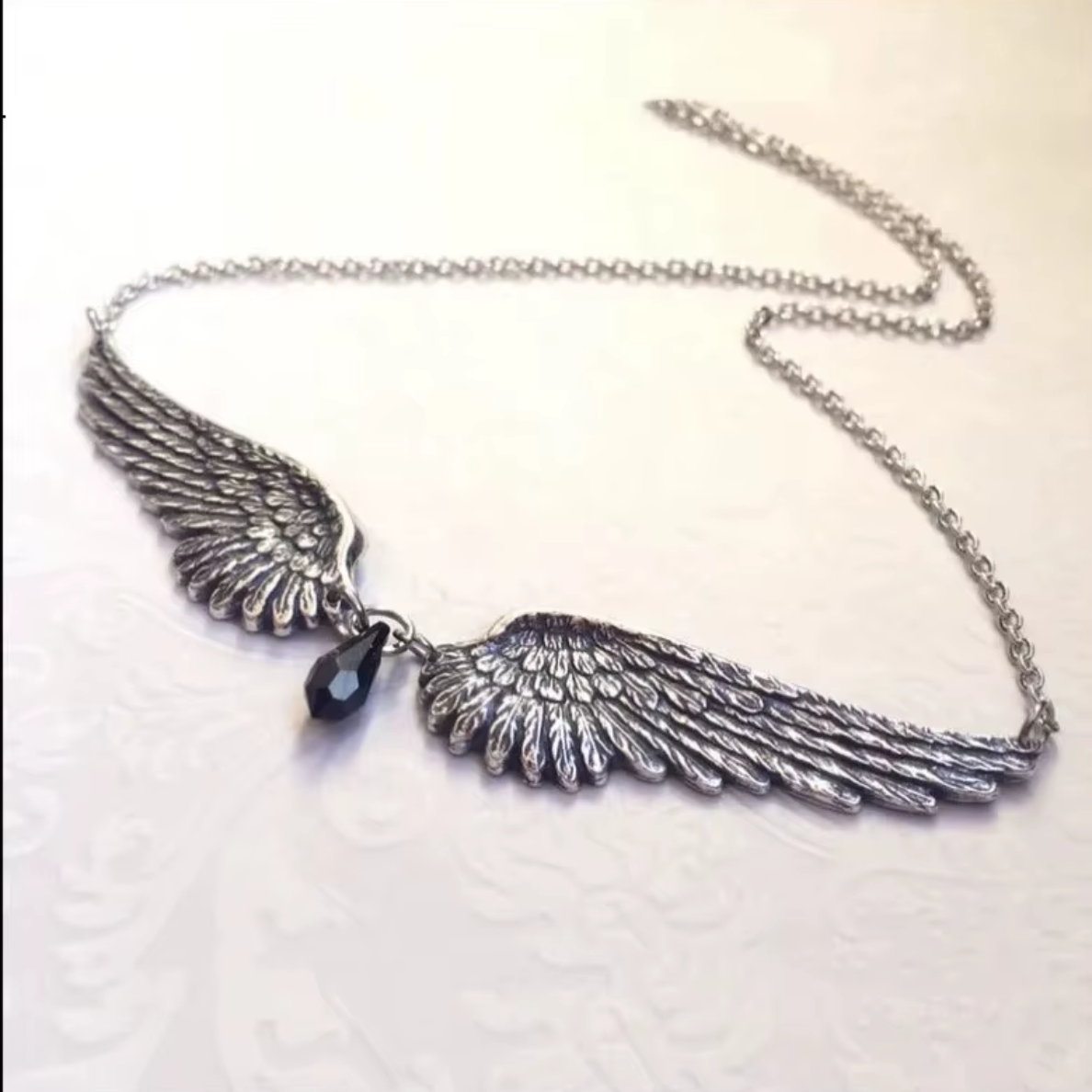 "Anielska Tarcza" – Naszyjnik ze Skrzydłami Anioła i Czarnym Koralikiem